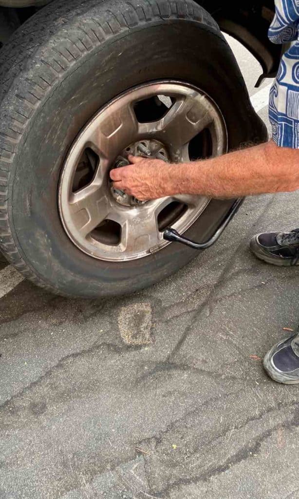man fixing a flat tire by replacing it with a spare